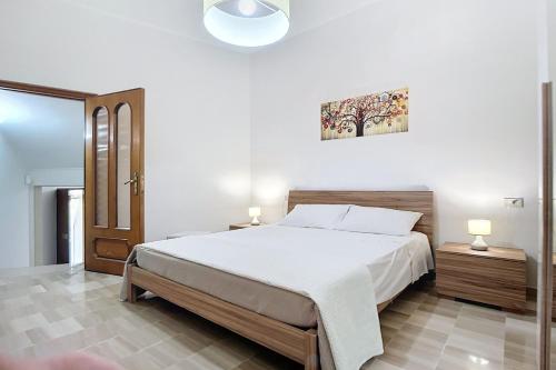 a bedroom with a large bed and two lamps at Villa La Tesa in Monte SantʼAngelo
