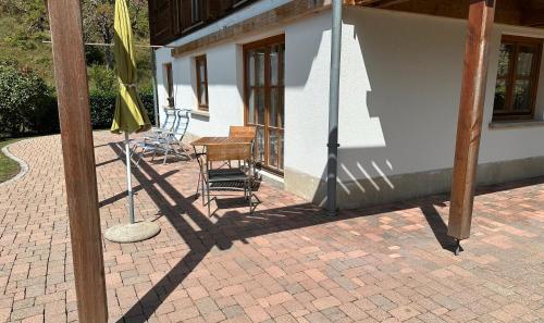 a patio with chairs and a table and a building at Ferienwohnung Kleines Wiesental in Kleines Wiesental