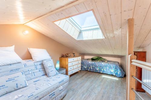 サン・ドニ・ドレロンにあるLe Petit Appartement de Saint-Denisのベッドと天窓のある屋根裏部屋の寝室