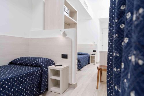a bedroom with two beds with blue polka dot sheets at Hotel Giotto in Padova