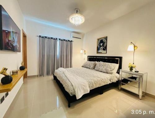 サンティアゴ・デ・ロス・カバリェロスにあるTranquilo y acogedorの大きなベッドとテレビのある寝室