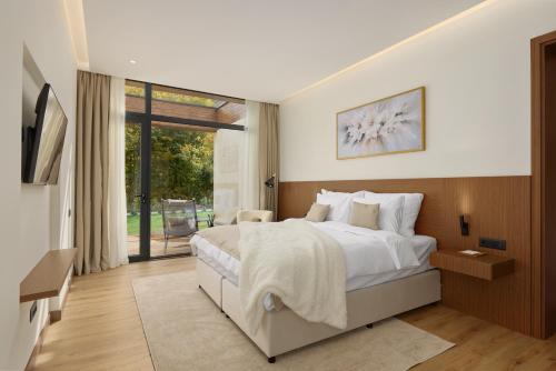 Un dormitorio con una cama grande y una puerta corrediza de vidrio. en Terra Homes, en Kolašin