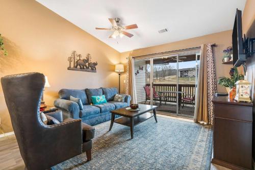 Stunning Water View - Pet Friendly Indoor Pool في برانسون: غرفة معيشة مع أريكة زرقاء وتلفزيون