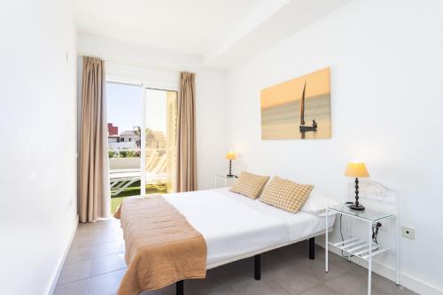 a white bedroom with a bed and a balcony at Eden Rentals Pure Abona in Poris de Abona