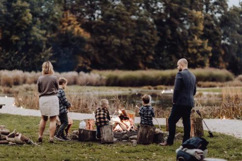 uma família em volta de uma fogueira em um campo em For-Rest Lodge em Broekhuizen