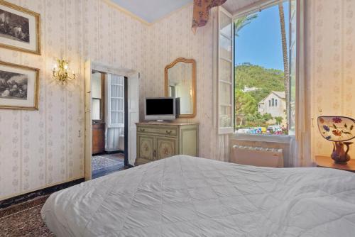 a bedroom with a bed and a television and a window at Piazza 100 Croci in Bonassola
