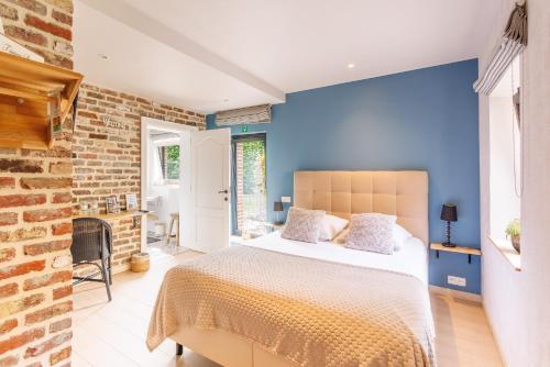 a bedroom with a bed and a blue wall at B&B Hof Ter Koningen in Aalst