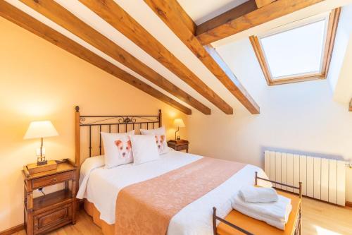 a bedroom with a large bed with wooden ceilings at Casa el Arroyal in Rades de Abajo