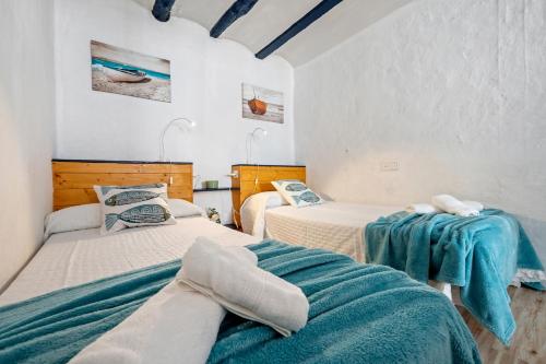 een slaapkamer met 2 bedden met blauwe lakens bij Loft Sf5 in L'Ametlla de Mar