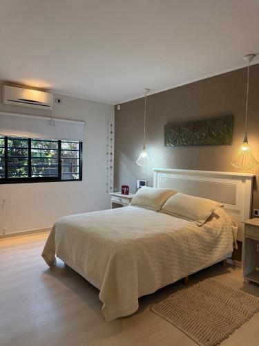 a bedroom with a large bed and a window at Sumergite en una gran piscina o jacuzzi in Gualeguaychú