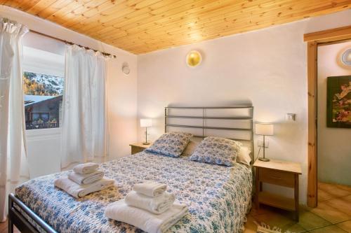 een slaapkamer met een bed met handdoeken erop bij Maison Esterina vista Monte Bianco in Courmayeur