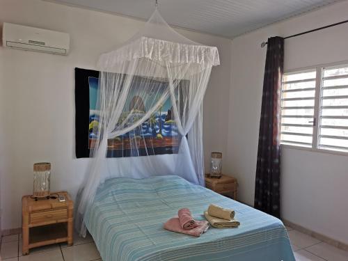 レ・トロワ・イレにあるT3 Hibiscusのベッドとタオル2枚のある寝室