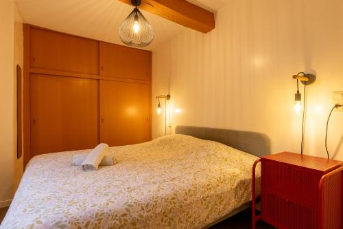 a bedroom with a bed and a cabinet and a lamp at Cocon' Aire Charmant appartement au calme, proche centre, wifi in Aire-sur-lʼAdour