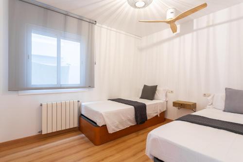 a bedroom with two beds and a window at Apartamento Palomera Blanes in Blanes