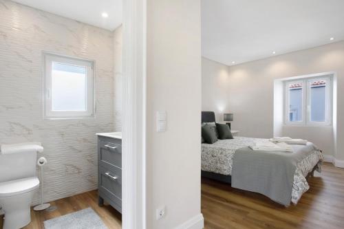 a white bedroom with a bed and a toilet at Casa d'Avó em Santa Bárbara in Casa Nova