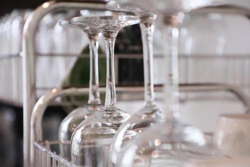 une rangée de verres à vin assis sur une étagère dans l'établissement Tiger House River Kwai, à Ban Tha Thong Mon