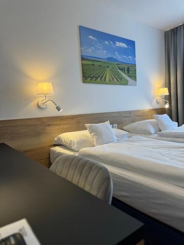 a hotel room with three beds and a table at Hotel ROSE Břeclav in Břeclav