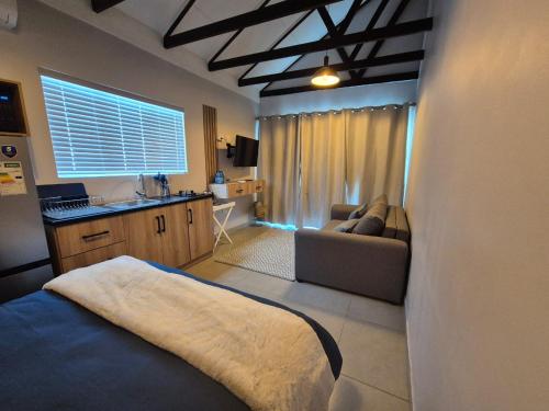 a bedroom with a bed and a couch and a kitchen at atnine in Welkom