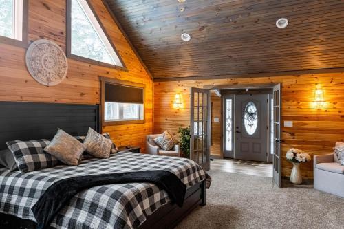 a bedroom with a bed in a room with wooden walls at Copper Kettle Lodge in Cook Forest in Sigel