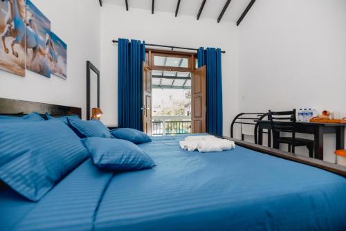 a large blue bed with blue pillows in a bedroom at Teya Beach Hotel in Ahangama