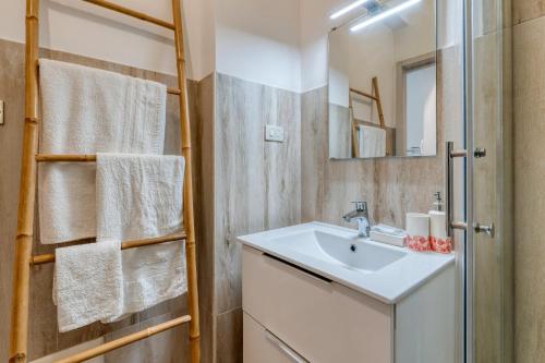 een badkamer met een wastafel en een spiegel bij Appartamento Corallo in Porto Cesareo