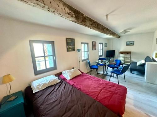 sypialnia z dużym czerwonym łóżkiem w pokoju w obiekcie studio cœur de ville 25 m2 avec vue cathédrale w mieście Narbona