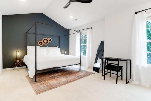 a bedroom with a black canopy bed and a desk at Boho Ferry- Mins from Credit One- Pet Friendly in Charleston