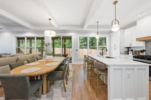 een keuken en woonkamer met een houten tafel en stoelen bij New Modern Luxurious Woodland Retreat home in Scottdale