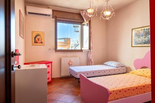 a bedroom with two beds and a window at Dimora La Reggia in Mesagne