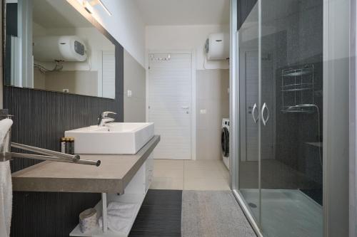 un baño con lavabo y ducha en La Casa Rossa, en Piombino