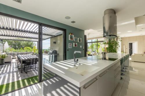 a kitchen with a large white counter and a patio at Prestigieuse Villa Spa 2 Piscines in Saint-Gély-du-Fesc