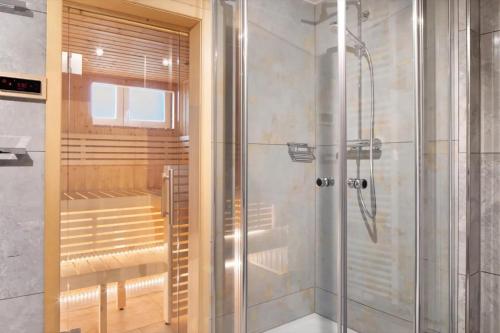 a shower with a glass door in a bathroom at Villa Skylodges mit 9 Wohnungen in Hofsgrund