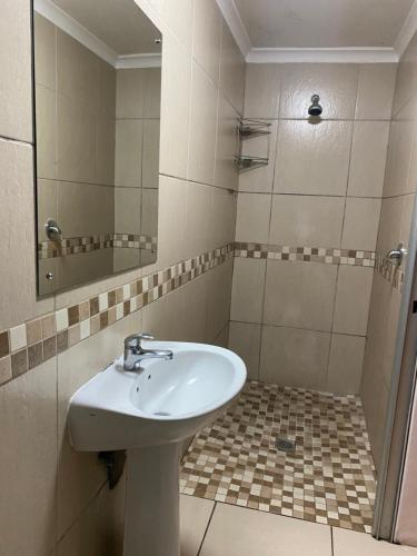 une salle de bain avec un lavabo et un miroir dans l'établissement Ludinz guest house self catering, au Cap