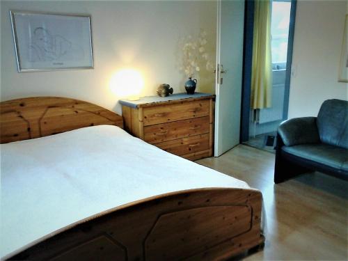 a bedroom with a bed and a couch and a chair at Haus Halligblick in Dagebüll