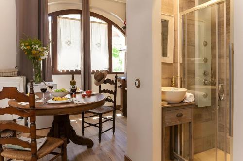 a dining room with a table and a shower at LEscala - Ventalló. Cosy WiFi Rooftop terrace in Ventalló