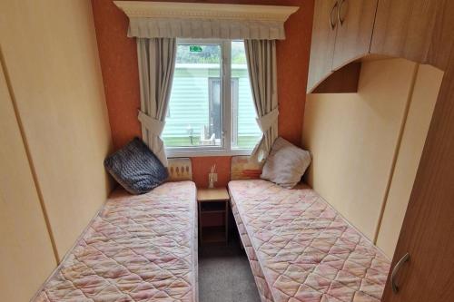 a small room with two beds and a window at 2 Bed Lodge - Parking Garden Site Facilities in Welshpool