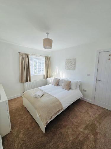 a white bedroom with a large white bed in it at 3 Bedroom Village Stay - Contractor and Professional Friendly Extended Stay Workspace in Kippax