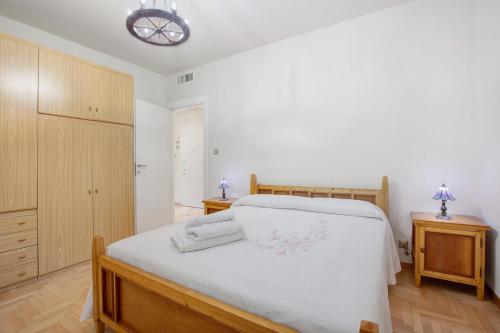 una camera da letto con un letto con lenzuola bianche e una lampada di La Mèison de la Louye ad Aosta