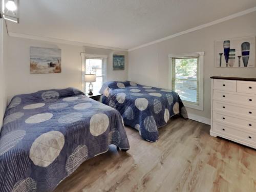 une chambre avec deux lits et une commode dans l'établissement Island Club #66, à Put-in-Bay