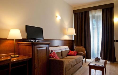 a living room with a couch and a flat screen tv at Hotel & Residence Torino Centro - Stazione Porta Susa in Turin