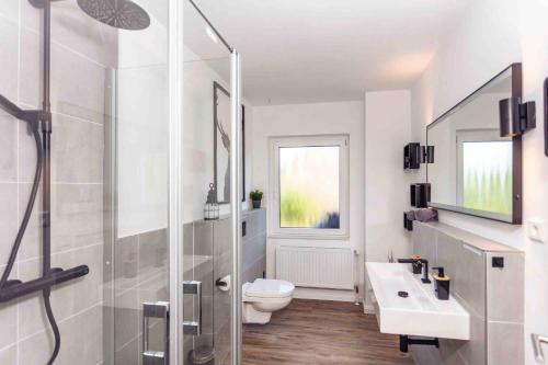 ビューズマー・ダイヒハウゼンにあるBüsumer Butzeのシャワー、トイレ、洗面台を備えたバスルーム