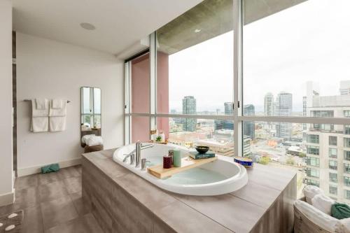a large bathroom with a tub and a large window at 2 Storey Penthouse Panoramic Views Parking Stampede in Calgary