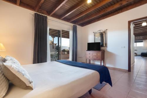 a bedroom with a large bed and a television at Almar in Tinajo