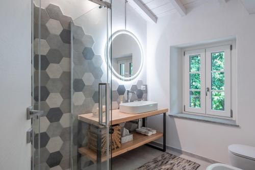 een badkamer met een wastafel en een spiegel bij Charming Tuscan Stone House in Pescaglia