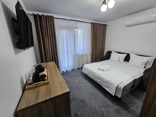 トゥルグ・ネアムツにあるStrăjerii Cetățiiのベッドルーム(ベッド1台、テレビ付きテーブル付)