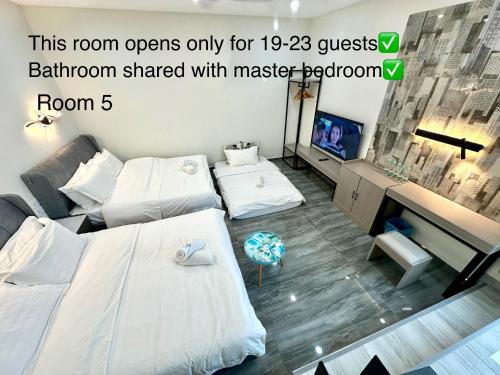 a room with two beds and a television at Stylish Villa Alma 18-23 Guests - Pool, KTV & BBQ in Simpang Ampat