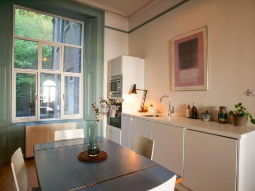 a kitchen with a table and a sink and a counter at Beautiful sea front apartment with balcony in St Leonards-on-Sea in Hollington