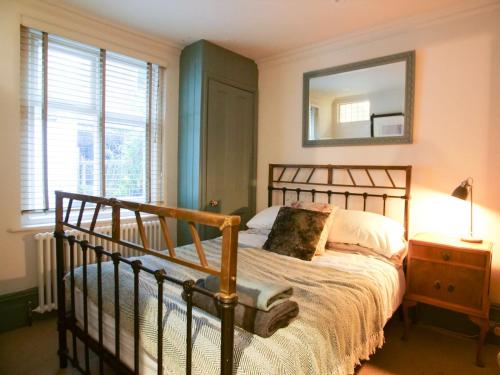 a bedroom with a bed and a mirror on the wall at Beautiful sea front apartment with balcony in St Leonards-on-Sea in Hollington