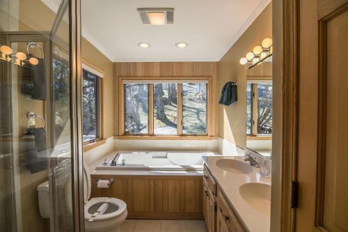 a bathroom with a tub and two sinks and a toilet at A Nest With a View in Blowing Rock