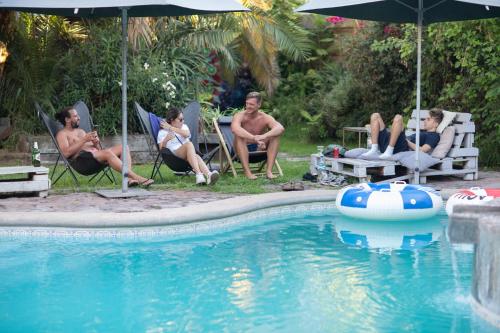 a group of people sitting around a swimming pool at La Casa Roja Hostel in Santiago